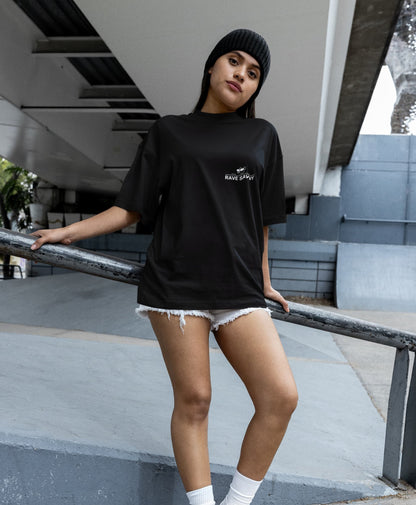 Mujer de etnia latina que lleva una camiseta negra oversize con el logo de "Rave Savvy"